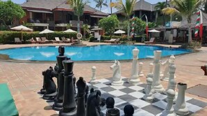 Un área junto a la piscina con un tablero de ajedrez listo para jugar.