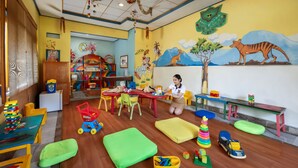 A children's playroom with colorful furniture, toys, and educational materials.