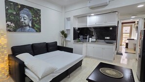 Un dormitorio moderno con una cama, una mesita de noche y una lámpara fijada a la pared.