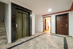A hallway with a marble floor, a staircase, and two doors. - Superbe face Jardin Majorelle | Piscine & Parking (Marrakesh)