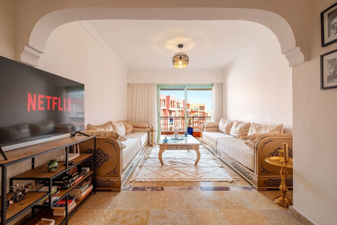 A living room with a television, sofas, a coffee table, and a bookshelf.