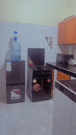 Eine Küche mit Kühlschrank, Herd und Mikrowelle.