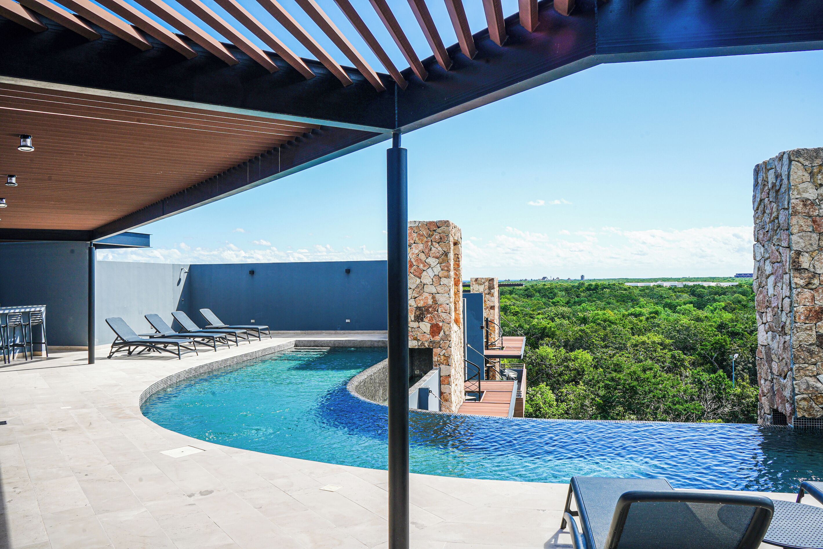 A pool area with lounge chairs and a view of the surrounding landscape.