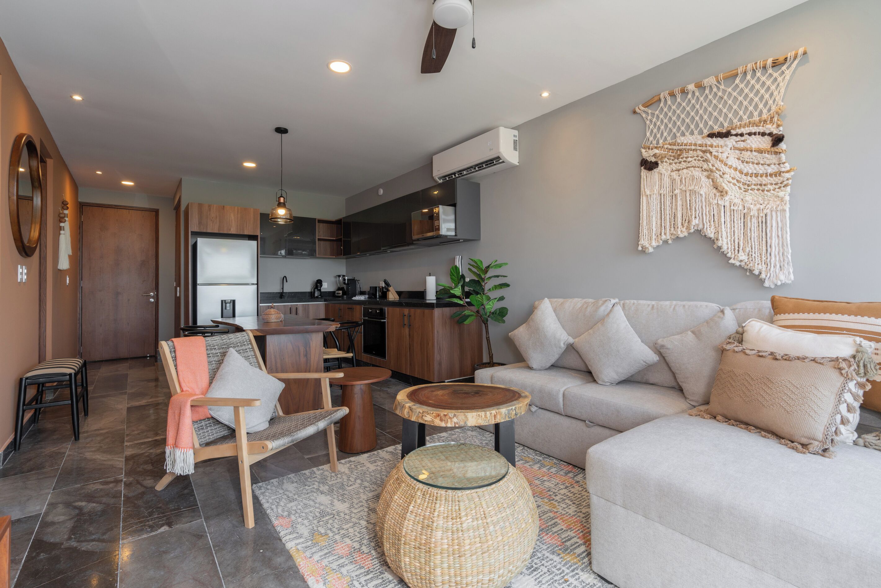 Un salon moderne comprenant un canapé, une table basse et un coin repas avec des chaises.