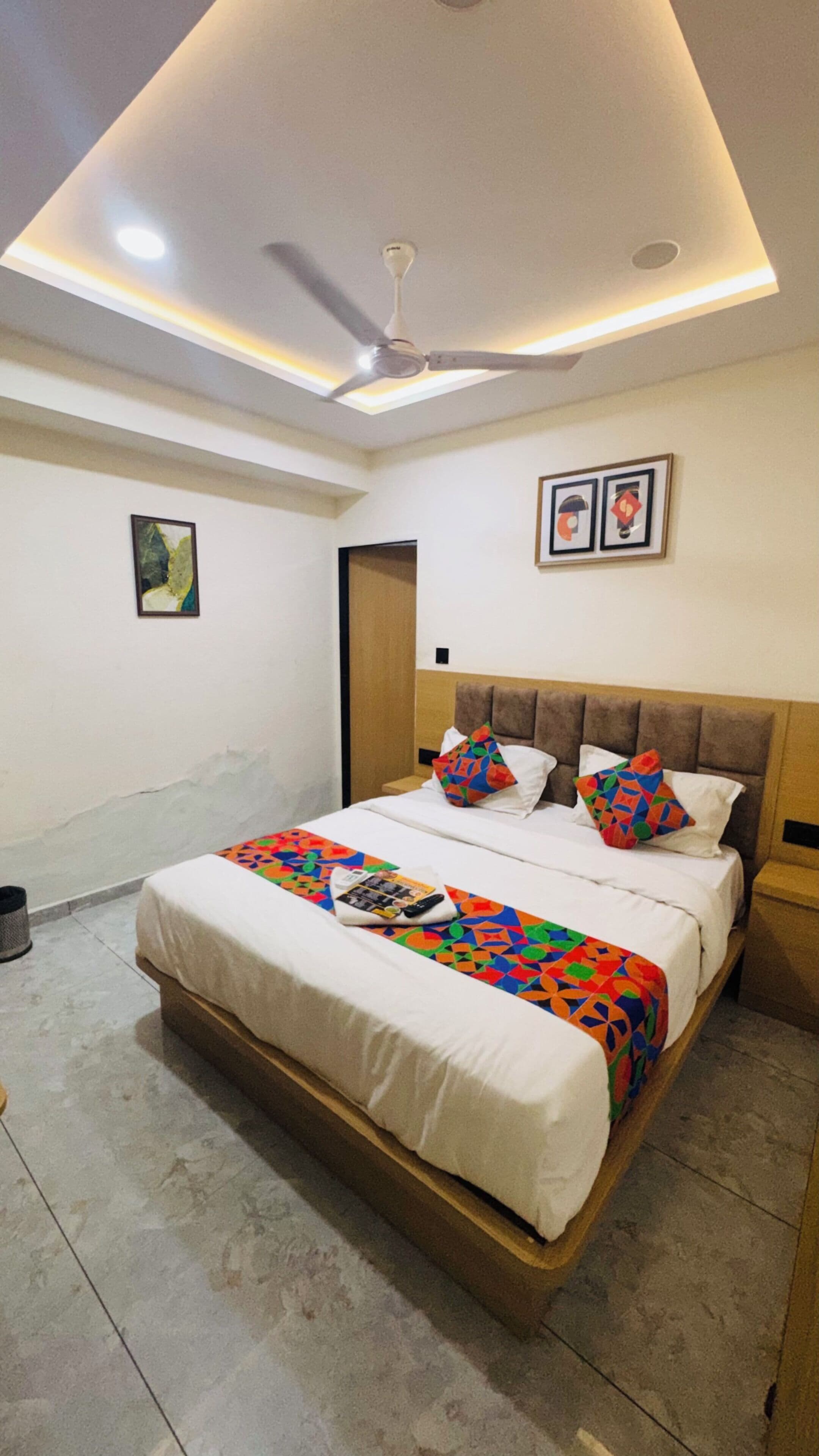 A bedroom with a bed, a ceiling fan, and a door.