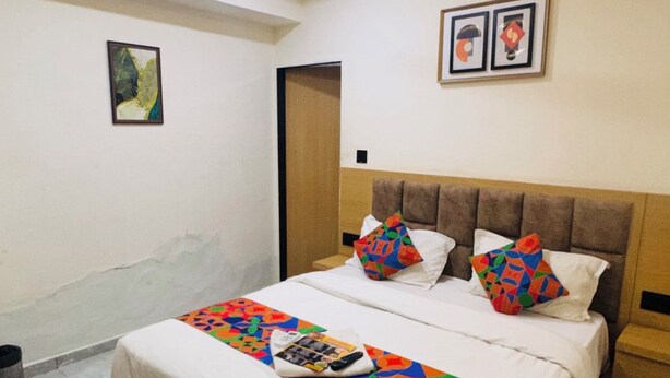 A bedroom with a bed, a ceiling fan, and a door. - Hotel sun town (Ahmedabad)