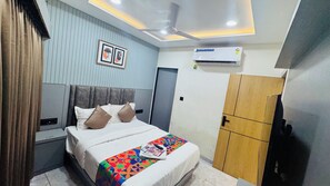 Ein Schlafzimmer mit Bett, Kleiderschrank, Klimaanlage und Deckenventilator.