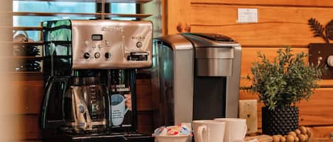 Una cocina con cafetera, tostadora y una planta en la encimera.