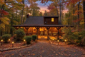 A log cabin with a porch, a front door, and a small window. - Smoky Mtn Retreat Hot Tub Fire Table EV Pets OK (Sevierville)