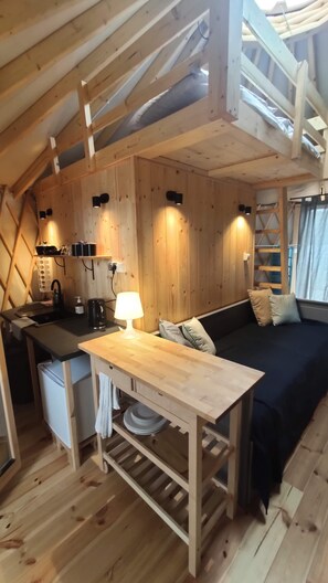 Ein gemütliches Holzhaus mit Küchenzeile, Esstisch und einer Sitzecke.