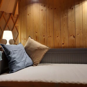 A bed with two pillows, a lamp, and wooden paneling on the wall. - Cztery Stawy Glamp - Yurt Genghis Khan (Ruda Różaniecka)