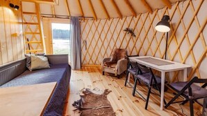 Un interior acogedor con piso de madera, un sofá, una mesa y una silla.