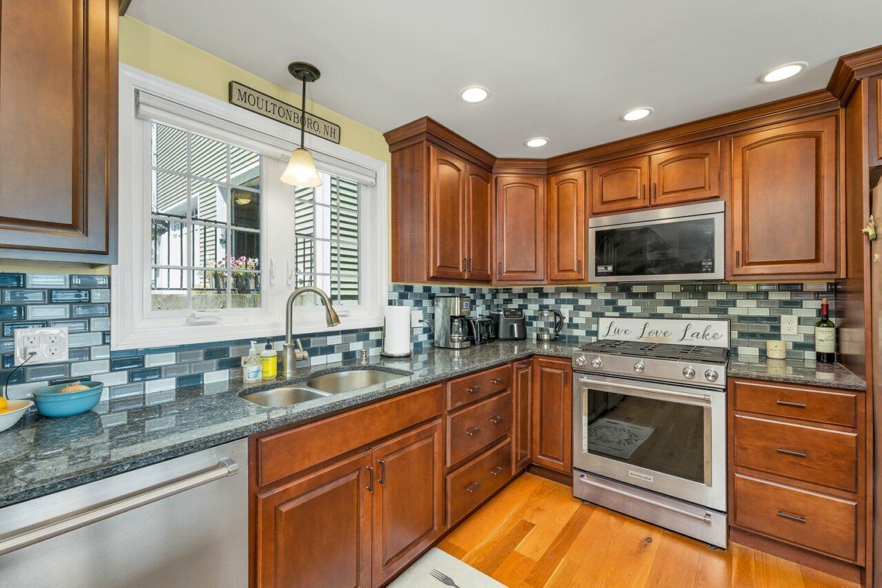 A kitchen with wooden cabinets, a stainless steel stove, and a tiled backsplash.