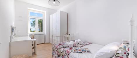 Un dormitorio con una cama, un escritorio y una ventana.