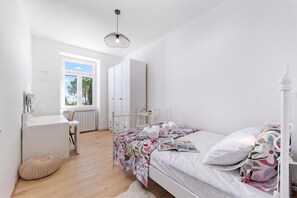 Ein Schlafzimmer mit einem Bett, einem Schreibtisch und einem Fenster.