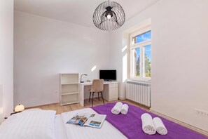 A bedroom with a bed, a desk, a chair, a TV, and a window with a view. - Seaview and Terrace Apartment La Vita (Kostrena)