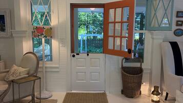 A room with a white door, a wicker basket, a lamp, and a chair.