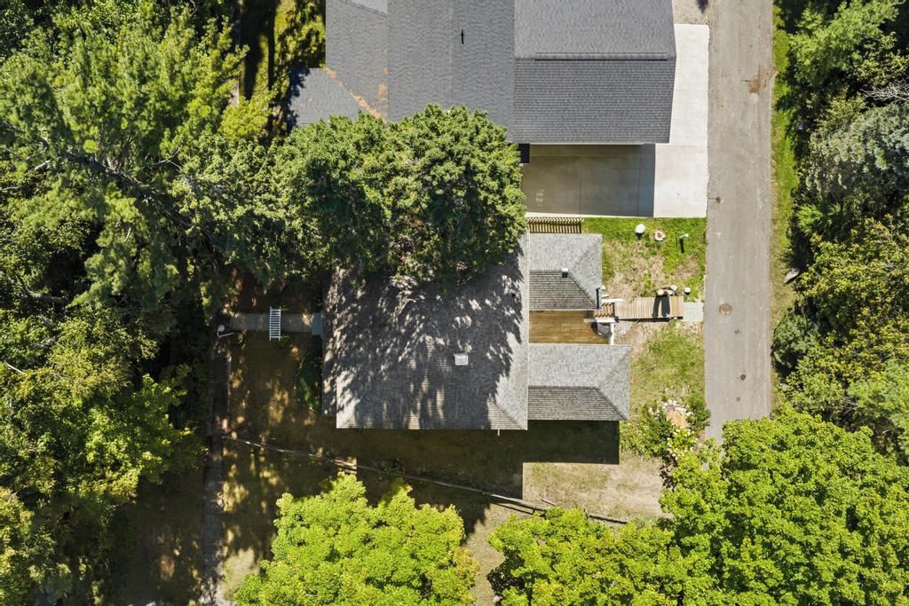 A residential property with a two-story structure, a visible garage, and a small front yard.