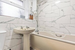 A bathroom with a sink, bathtub, and shower. - #109 Modern 3-Bed Home in Moseley (Balsall Heath)