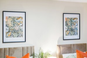 A hotel room with two beds, each with a headboard, and two framed floral artworks on the wall. - #109 Modern 3-Bed Home in Moseley (Balsall Heath)