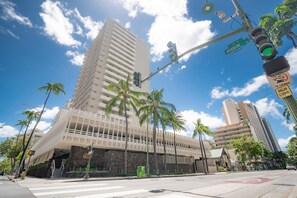 A modern building with a unique architectural design, featuring a prominent sloped roof and multiple balconies. - Just Renovated Marine Surf Corner Unit with Free Parking! (Honolulu)