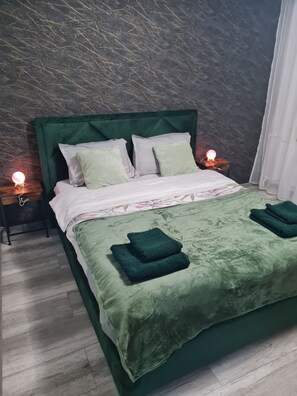 A bed with a green headboard, white bedding, and two bedside lamps. - Bright & Cosy Apartment with Sunset View in Bucharest (București)