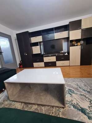 A modern kitchen with a built-in stove, black and beige cabinets, and a white countertop. - Bright & Cosy Apartment with Sunset View in Bucharest (București)
