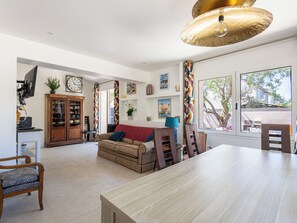 A spacious living area with a dining table, a sofa, a television, and a cabinet. - (107) A la Joie de vivre 2 (Cannes)