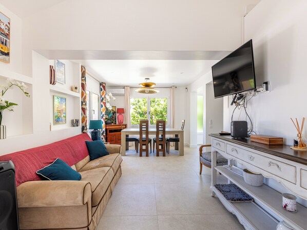 A modern living room with a sofa, TV, and dining area. - (107) A la Joie de vivre 2 (Cannes)