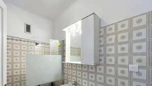 A bathroom with patterned tiles, a mirror, and a white cabinet. - Spacious studio, terrace, sea view - 2 guests (Menton)