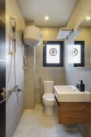 Une salle de bain moderne équipée de toilettes, d’une douche et d’un lavabo.