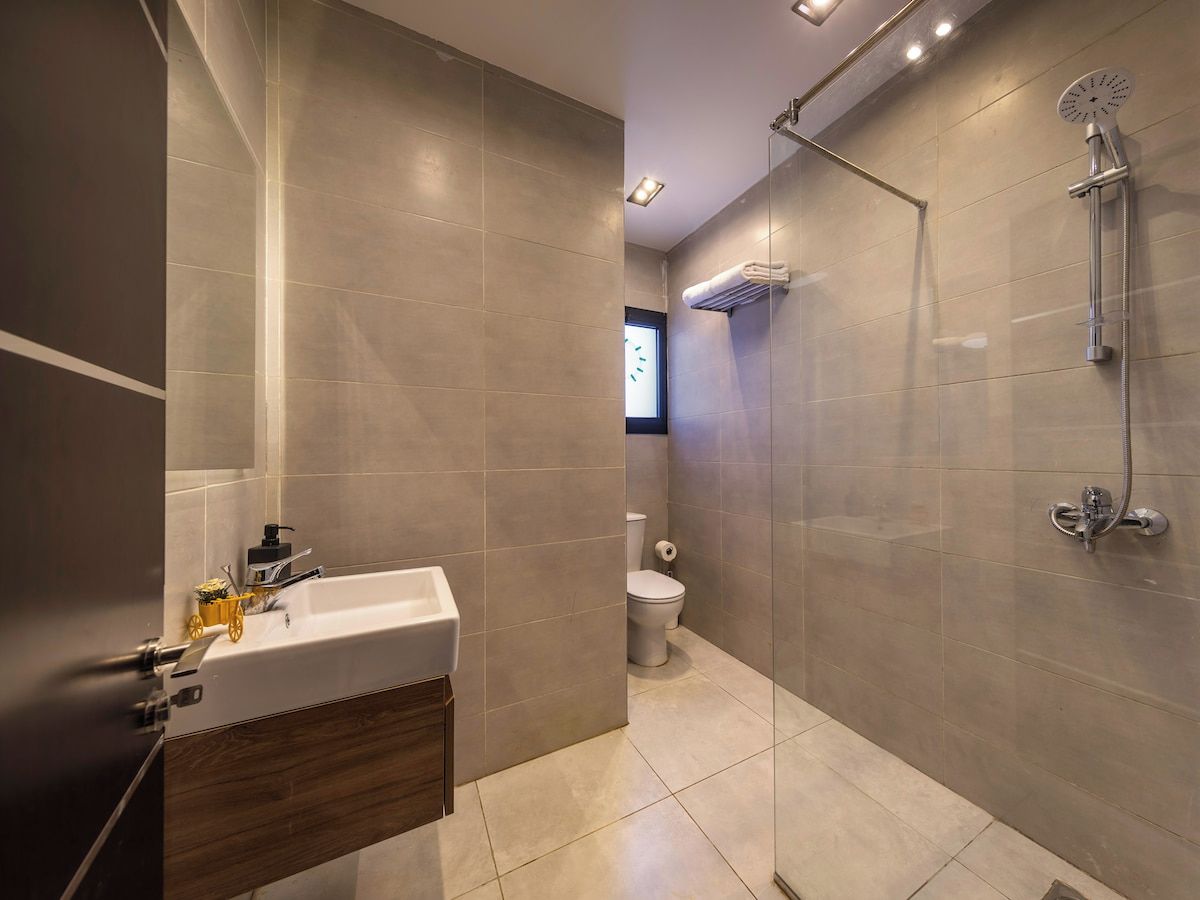 Un baño moderno con ducha, inodoro y lavamanos.