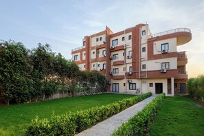 A multi-story residential building with a central courtyard, surrounded by greenery. - Golden Gates Residence (El Mokkatam)