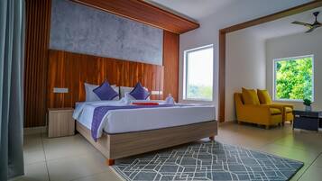 A modern bedroom with a large bed, wooden headboard, and a view of greenery outside.