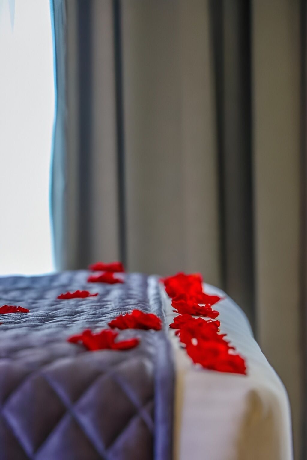 A bed with a quilted headboard and a white mattress.