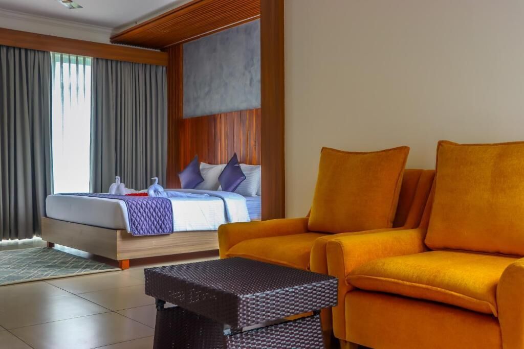 Una habitación de hotel con una cama, un sofá y una mesita.