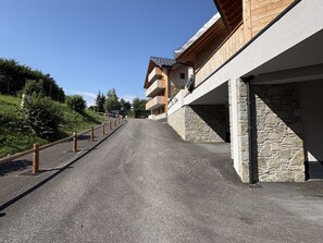 Eine Straße in einem Skigebiet, gesäumt von Holzhäusern und Steinmauern.