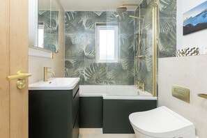 A bathroom with a shower, a sink, and a toilet. - Cosy 2BDR Home with Garden Near Canada Water (Greater London)