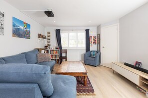 Ein modernes Wohnzimmer mit einer Couch, einem Couchtisch und einem Bücherregal.