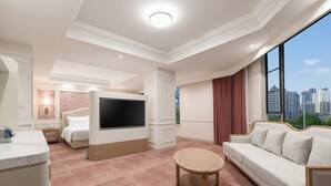 A hotel room with a bed, a TV, a sofa, a small table, and a view of the city. - Zhongjian Xingfu Hotel (Hankou Railway Station Branch), Wuhan (Wuhan)