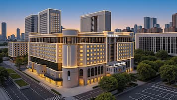 A multi-story hotel with a modern architectural design, featuring a prominent entrance and a well-lit facade.