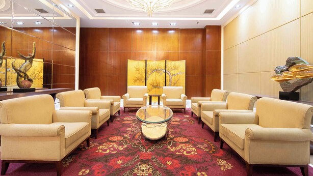 A hotel lobby with a central seating area, a chandelier, and a large artwork on the wall. - Zhongjian Xingfu Hotel (Hankou Railway Station Branch), Wuhan (Wuhan)