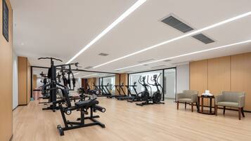 Un gimnasio moderno con diversos equipos de ejercicio, incluyendo cintas de correr y máquinas de pesas.