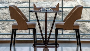 Mesa de comedor con dos sillas, con un paisaje montañoso y cielo despejado de fondo.