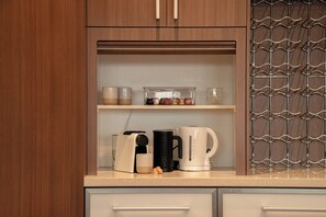 Eine Küche mit Holzausstattung, einer Arbeitsplatte und einer Kaffeemaschine.