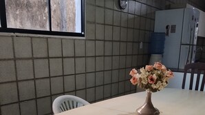 Ein Essbereich mit Tisch, Stühlen und einem Blumenstrauß.