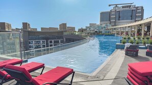 A rooftop swimming pool with lounge chairs and a view of surrounding buildings. - Free Housekeeping Visits During Your Stay - Stayshort - Prime 1 Bedroom Sleeps 2 in Palm Jumeirah (Dubai)