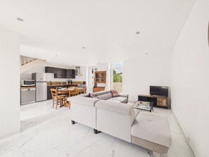 Un espacio habitable moderno con cocina, comedor y un sofá grande.