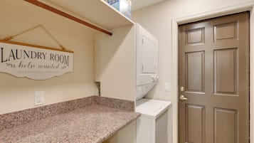 A laundry room with a sign, a countertop, a washing machine, and a door.
