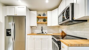 A modern kitchen with white cabinets, stainless steel appliances, and wooden countertops. - Modern 2-unit Combo w/ Pool: 'naples Hideaway' (Naples)